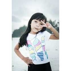 Portrait of cute girl gesturing on snow covered field