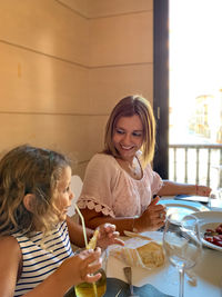 Mother and daughter sitting at restaurant