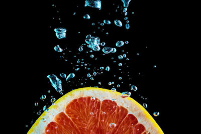 Close-up of water drops on glass against black background