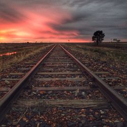 Railroad tracks against sky during sunset
