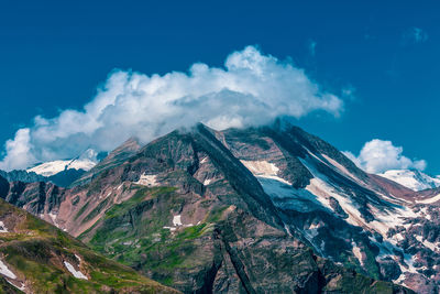 Scenic view of snowcapped mountains against blue sky