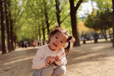 Portrait of smiling girl against trees
