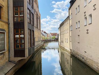 Canal amidst buildings against sky