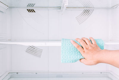 Cropped hands of woman cleaning fridge at home
