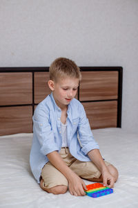 Boy sitting on bed at home