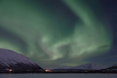 Aurora borealis over snowcapped mountains at night