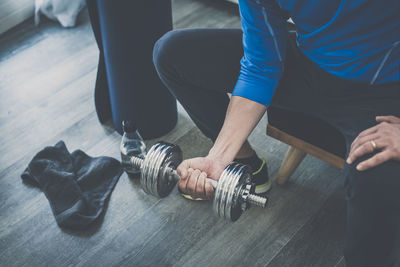 Sporty man working out and trains at home. fit boy doing exercises for biceps in the living room. 