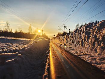 Surface level of railroad tracks against sky during winter