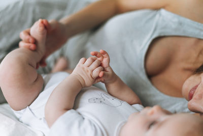 Young mother having fun with cute baby girl on bed, natural tones, love emotion