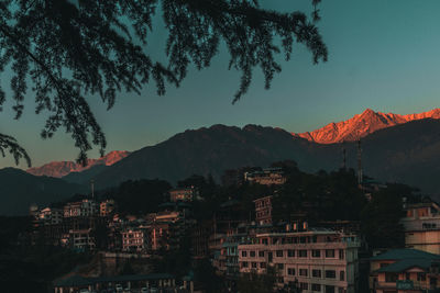 High angle view of townscape and mountains against sky at sunset