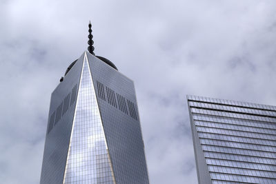 Low angle view of office blocks against clouds