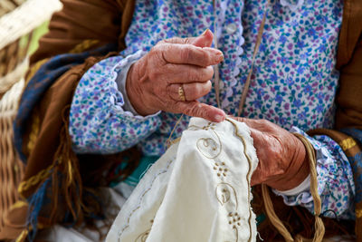 Midsection of woman weaving fabric