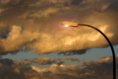 Low angle view of street light against orange sky