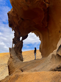 Rear view of man standing on rock formations