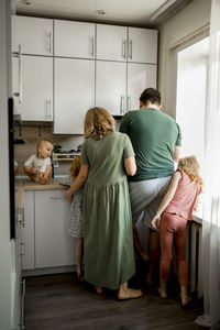 Mother and father with children standing in kitchen