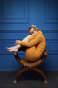 Portrait of woman sitting on sofa at home