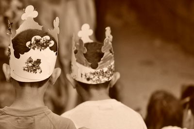 Rear view of two children wearing paper crown