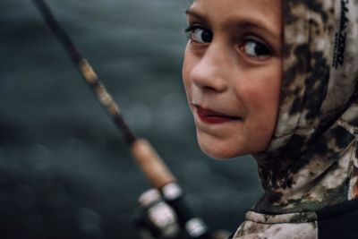 Close-up portrait of girl fishing in lake