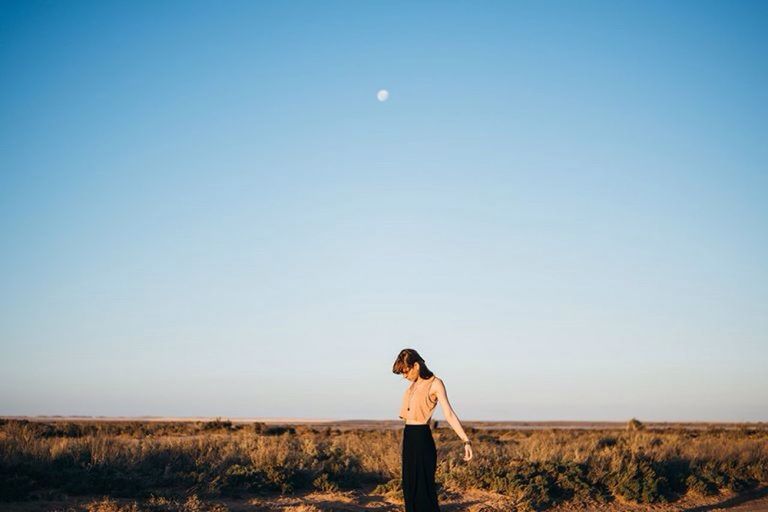 sky, standing, landscape, clear sky, environment, land, nature, young adult, one person, moon, casual clothing, adult, blue, women, field, real people, beauty in nature, leisure activity, copy space, outdoors, contemplation