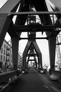 Road by bridge in city against sky