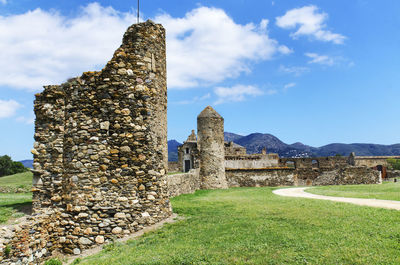 Old ruins of castle on field against sky