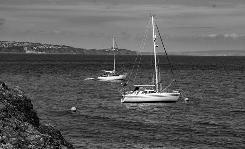 Boats sailing in sea against sky