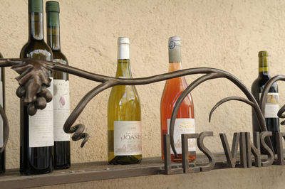 Close-up of wine bottles against wall