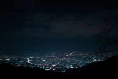 Illuminated cityscape against sky at night