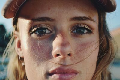 Close-up portrait of young woman wearing cap