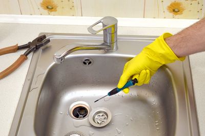 Cropped image of person repairing sink