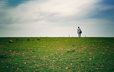 Man standing on field against sky