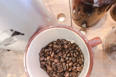 High angle view of roasted coffee beans in cup on table