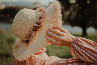 Close-up of woman holding hat