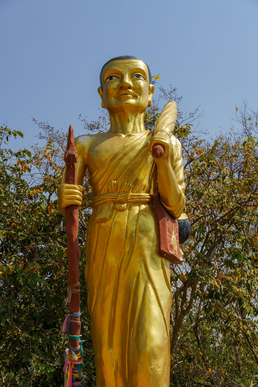 statue, sculpture, religion, gold, belief, monument, human representation, spirituality, sky, temple, yellow, nature, plant, male likeness, architecture, representation, clear sky, temple - building, low angle view, no people, outdoors, day, culture, craft, tree, travel destinations, history