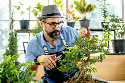 Man pruning plants in botany