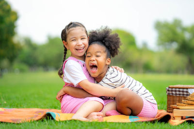 Portrait of a smiling young woman sitting on field