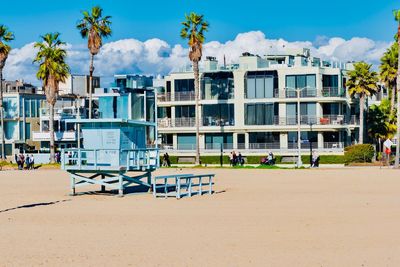 Built structure on beach by buildings against sky