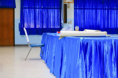 Empty chairs and tables in bed against building