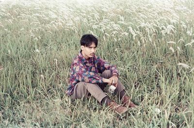 Woman sitting on grass in field