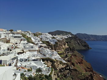 Panoramic view of buildings and sea against clear blue sky