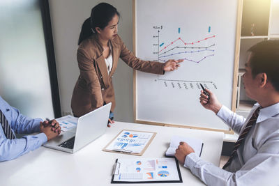 Business people discussing over graph in office