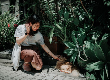 Portrait of young woman sitting on plants