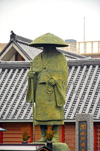 Statue outside house against sky