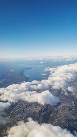 Aerial view of clouds over landscape against blue sky