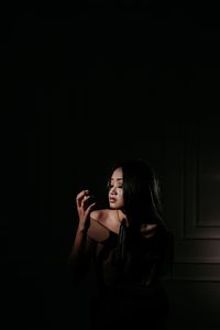 Young woman looking away against black background