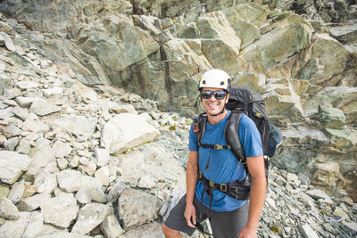 Portrait of mountaineer wearing helmet and backpack.