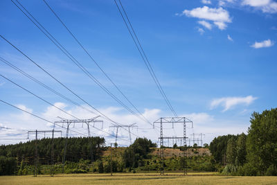 Electricity pylons against blue sky