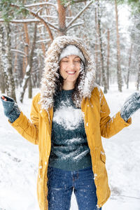 Portrait of a smiling woman standing in snow