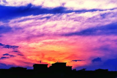 Low angle view of silhouette buildings against sky