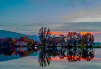 Reflection of trees in lake against sky during sunset